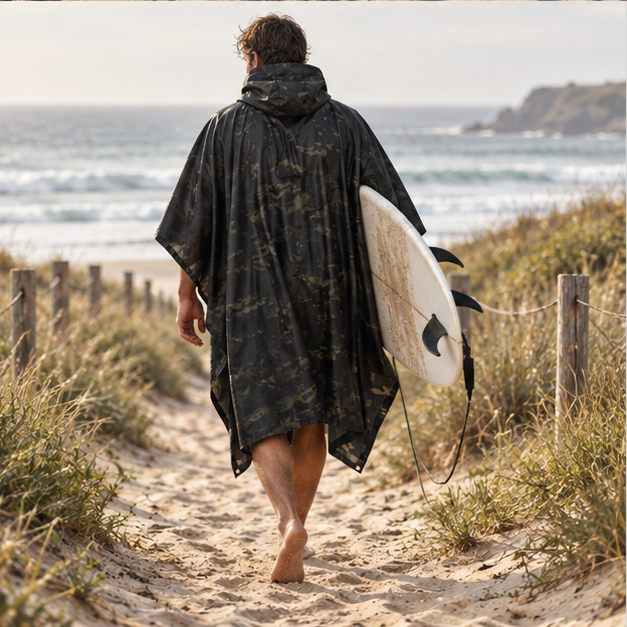 Poncho Camouflage Noir – Noir / Adulte, porté en mouvement au bord de l’océan