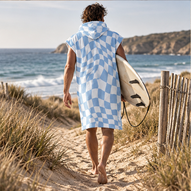 Poncho De Bain Damier Bleu – Blanc / Adulte, porté en mouvement au bord de l’océan