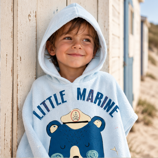 Poncho De Bain Enfant Little Marine – Bleu Clair / Enfant, dans un intérieur côtier lumineux