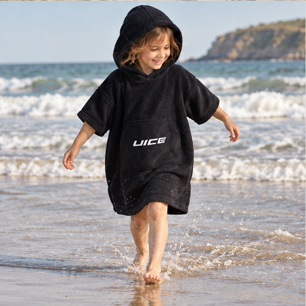 Poncho De Bain Enfant Noir – Noir / Enfant, porté en mouvement au bord de l’océan