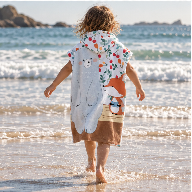 Poncho De Bain Enfant Ours et Renard – Bleu Clair / Enfant, porté en mouvement au bord de l’océan
