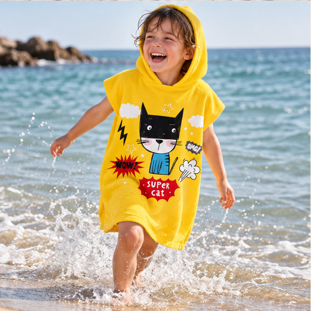 Poncho De Bain Enfant Super Cat – Jaune / Enfant, porté en mouvement au bord de l’océan