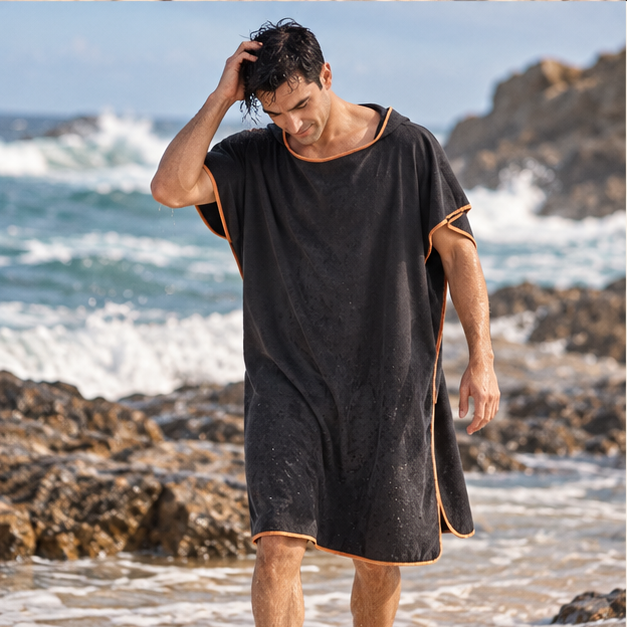 Poncho De Bain Microfibre – Noir / Adulte, porté en mouvement au bord de l’océan