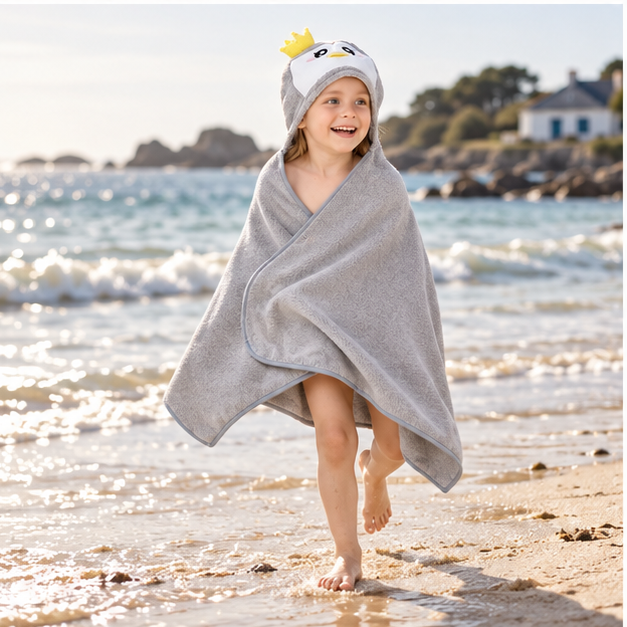 Poncho De Bain Pingouin Gris – Gris / Bébé, porté en mouvement au bord de l’océan