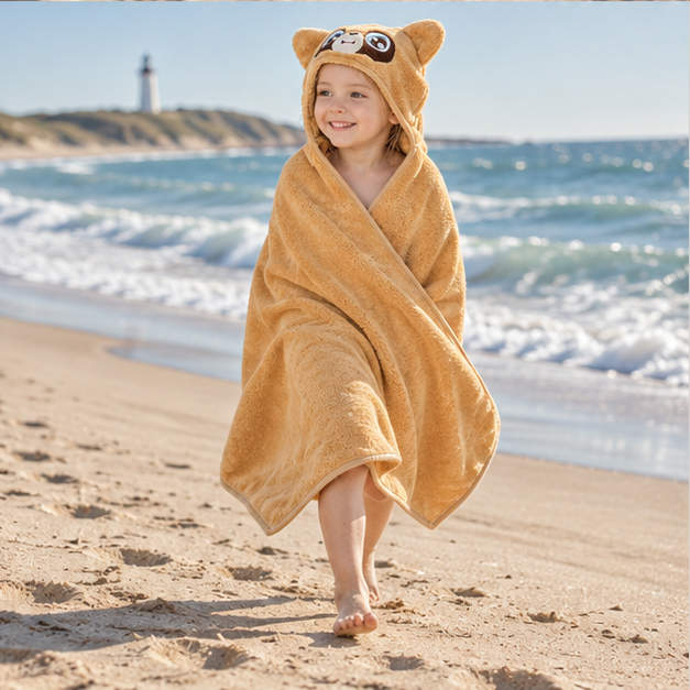 Poncho De Bain Raton Laveur – Marron / Bébé, porté en mouvement au bord de l’océan