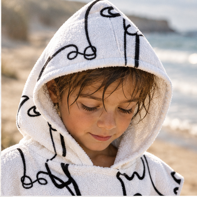 Poncho De Bain Visages – Blanc / Adulte, dans un intérieur côtier lumineux
