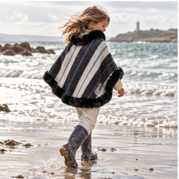 Poncho Fourrure Rayure – Noir / Adulte, porté en mouvement au bord de l’océan