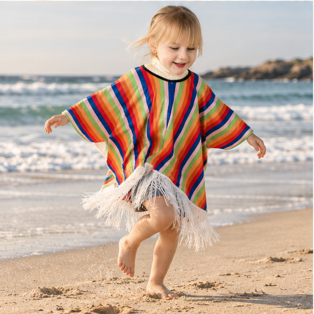 Poncho Mexicain Enfant À Rayures Verticales – Orange / Enfant, porté en mouvement au bord de l’océan
