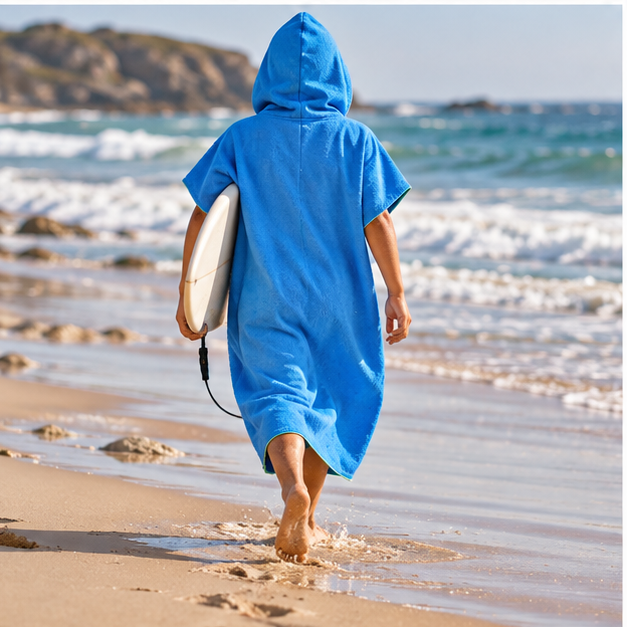 Poncho Microfibre Bleu – Bleu / Adulte, porté en mouvement au bord de l’océan