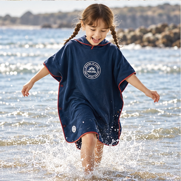 Poncho Microfibre Enfant – Gris Bleuté / M, Gris Bleuté / L, porté en mouvement au bord de l’océan