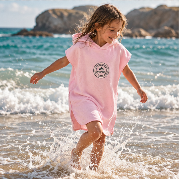 Poncho Microfibre Enfant – Rose / M, Rose / L, porté en mouvement au bord de l’océan