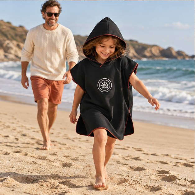 Poncho Microfibre Enfant – Noir / M, Noir / L, porté en mouvement au bord de l’océan