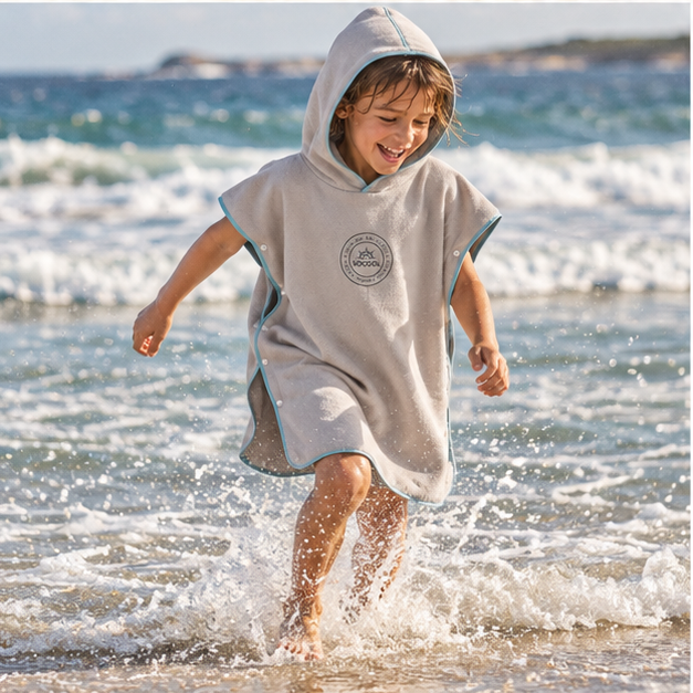 Poncho Microfibre Enfant – Gris / M, Gris / L, porté en mouvement au bord de l’océan
