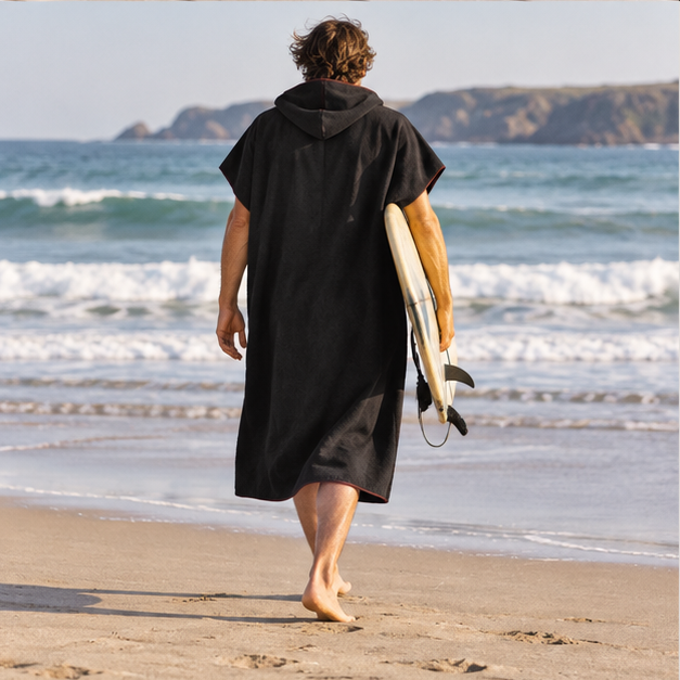 Poncho Microfibre Noir – Noir / Adulte, porté en mouvement au bord de l’océan