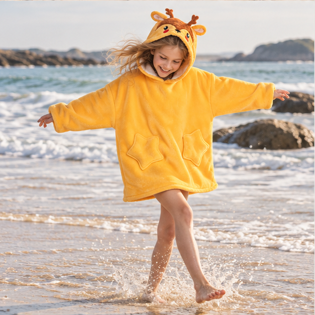 Poncho Plaid Cerf – Jaune / Enfant, porté en mouvement au bord de l’océan