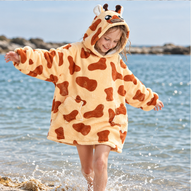Poncho Plaid Girafe – Jaune / Enfant, porté en mouvement au bord de l’océan