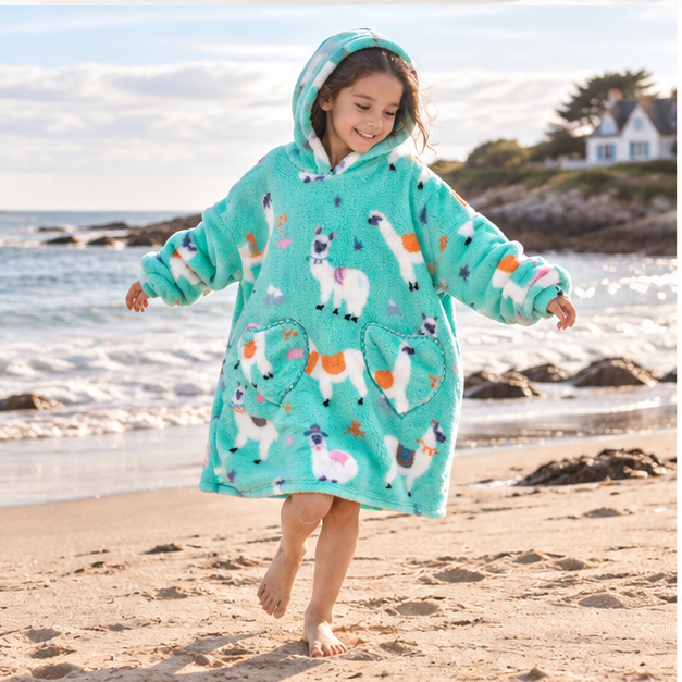 Poncho Plaid Lama – Turquoise / Enfant, porté en mouvement au bord de l’océan