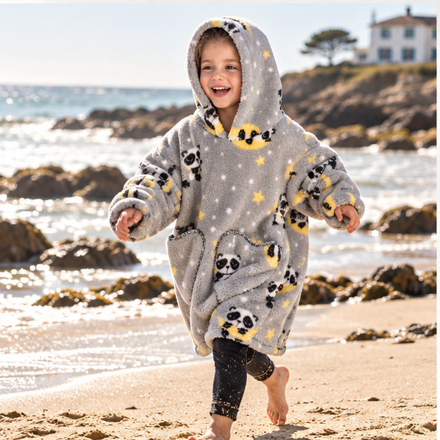Poncho Plaid Lune et Panda – Gris / Bébé, porté en mouvement au bord de l’océan