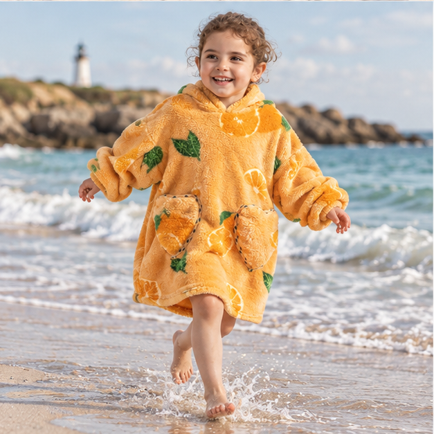 Poncho Plaid Orange – Orange / Bébé, porté en mouvement au bord de l’océan