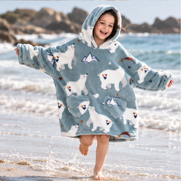 Poncho Plaid Ours Polaire – Bleu / Enfant, porté en mouvement au bord de l’océan