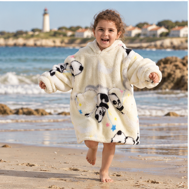 Poncho Plaid Panda, porté en mouvement au bord de l’océan