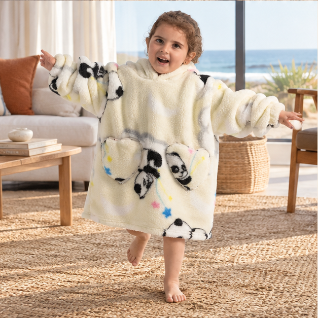 Poncho Plaid Panda – Beige / Bébé, porté en mouvement au bord de l’océan