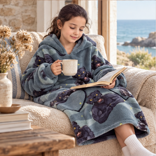 Poncho Plaid Panthère Noir, porté en mouvement au bord de l’océan