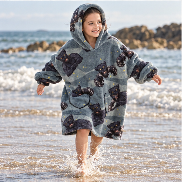 Poncho Plaid Panthère Noir – Gris Foncé / Enfant, porté en mouvement au bord de l’océan
