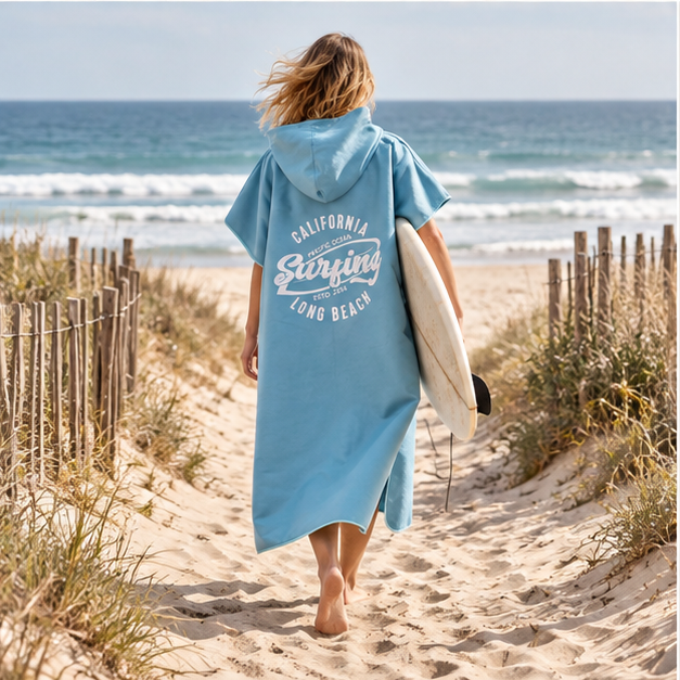 Poncho Surf Bleu – Bleu / Adulte, porté en mouvement au bord de l’océan