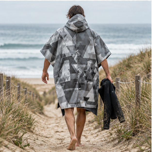 Poncho Surf Hiver – Gris / Adulte, porté en mouvement au bord de l’océan