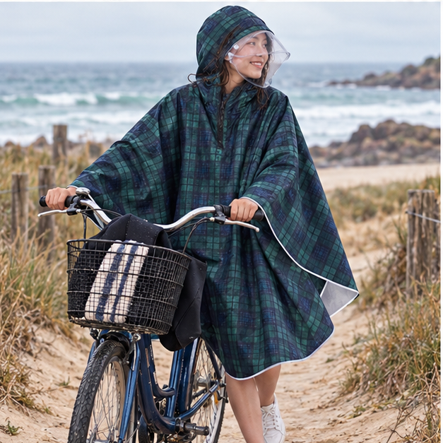 Poncho Vélo Pluie Carreaux – Vert Foncé / Adulte, porté en mouvement au bord de l’océan