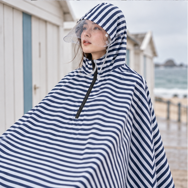 Poncho Vélo Pluie Marinière – Bleu Marine / Adulte, porté en mouvement au bord de l’océan