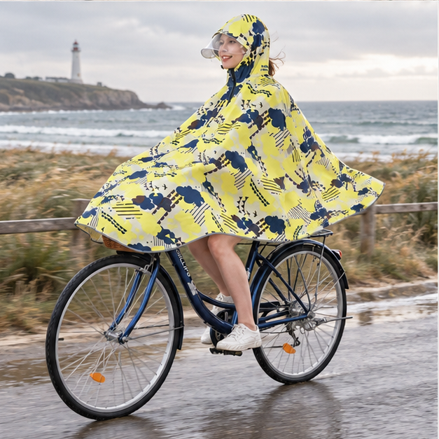 Poncho Vélo Pluie Motifs Nuages – Jaune / Adulte, porté en mouvement au bord de l’océan