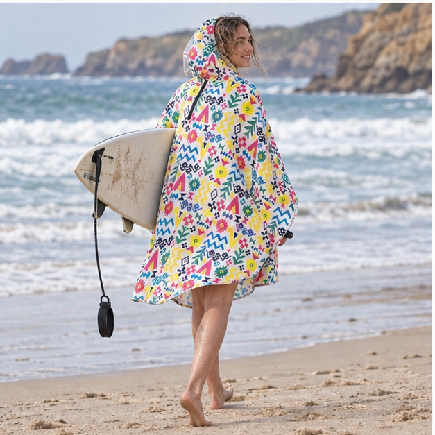 Poncho Vélo Pluie Multiples Motifs – Blanc / Adulte, porté en mouvement au bord de l’océan