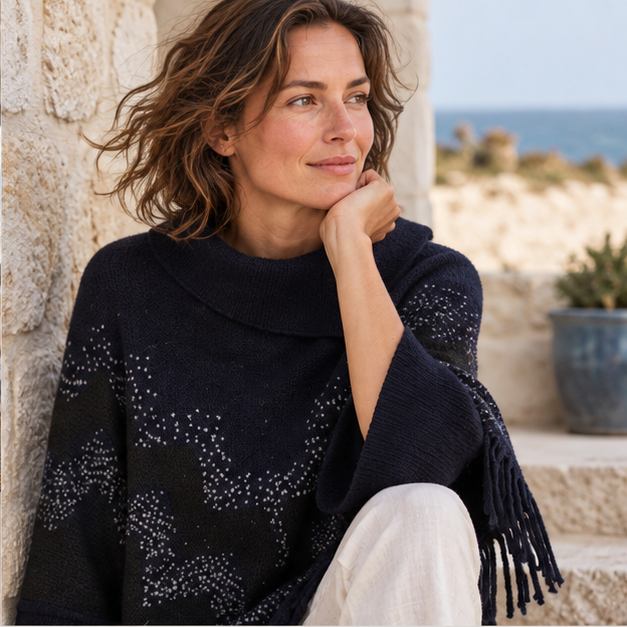 Pull Poncho à Franges – Noir / Adulte, dans un intérieur côtier lumineux