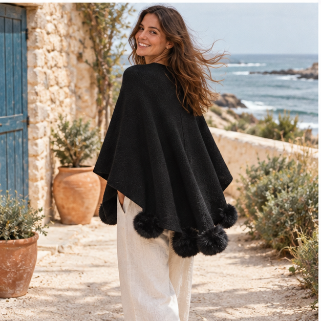Pull Poncho Pompon – Noir / Adulte, porté en mouvement au bord de l’océan