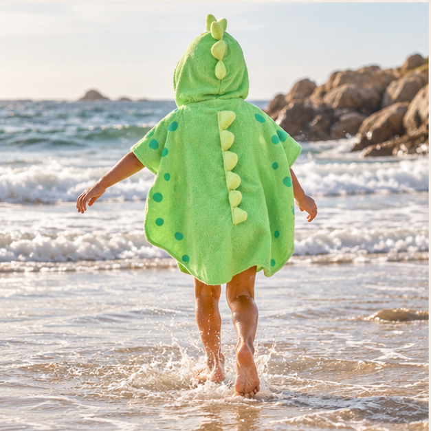 Serviette Poncho Dinosaure – Vert / Enfant, porté en mouvement au bord de l’océan